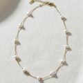 Pearl necklace on an elevated cream linen background