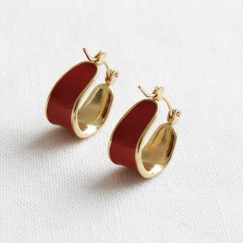 Red and gold hoop earrings on white linen